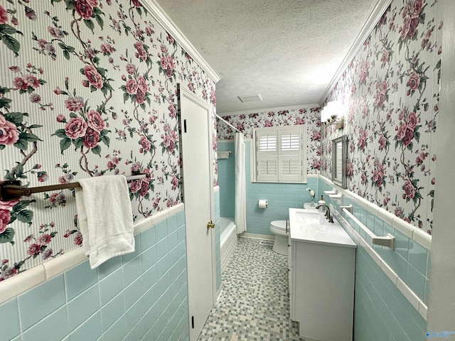 full bathroom with tile walls, toilet, vanity, and crown molding