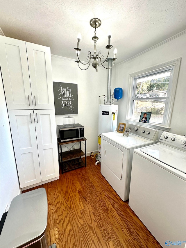 washroom with cabinets, dark hardwood / wood-style floors, gas water heater, a textured ceiling, and washing machine and dryer