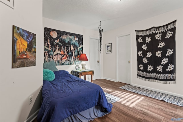 bedroom with wood-type flooring and a textured ceiling