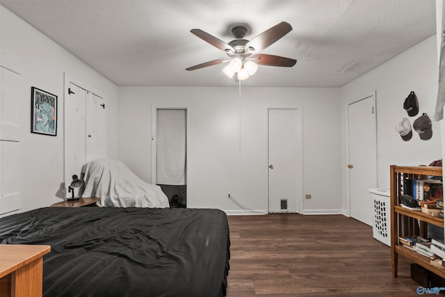 bedroom featuring two closets, ceiling fan, and dark hardwood / wood-style floors