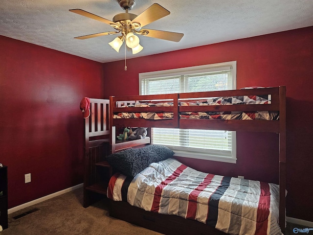 carpeted bedroom with multiple windows, a textured ceiling, and ceiling fan