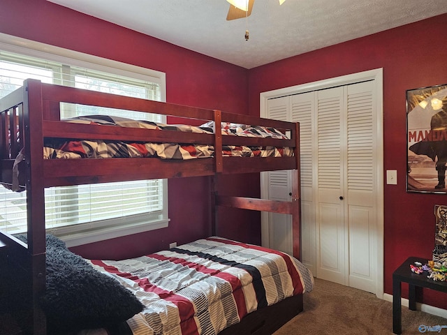 carpeted bedroom featuring ceiling fan, a textured ceiling, and a closet