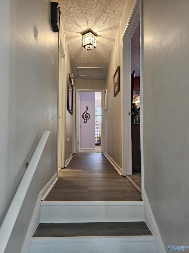 stairway featuring a textured ceiling and hardwood / wood-style floors