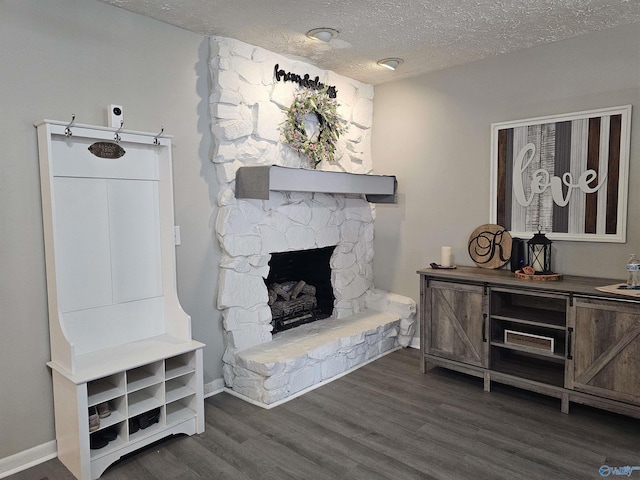 living room with a fireplace, dark hardwood / wood-style floors, and a textured ceiling
