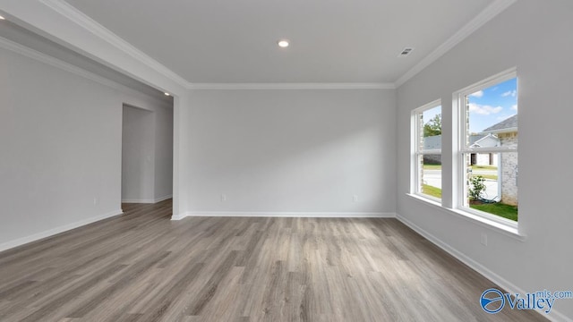 empty room with crown molding and light wood-type flooring