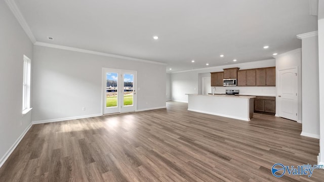 unfurnished living room with sink, crown molding, and wood-type flooring