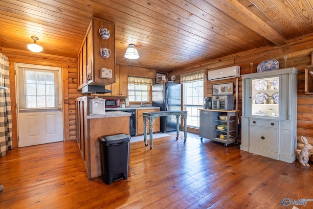 kitchen featuring a wall mounted air conditioner, hardwood / wood-style floors, wooden ceiling, and black appliances