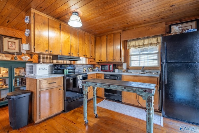 kitchen featuring sink, light hardwood / wood-style floors, wood ceiling, and black appliances