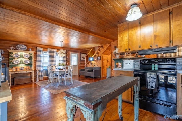 kitchen with wood walls, electric range, log walls, a notable chandelier, and dark hardwood / wood-style flooring