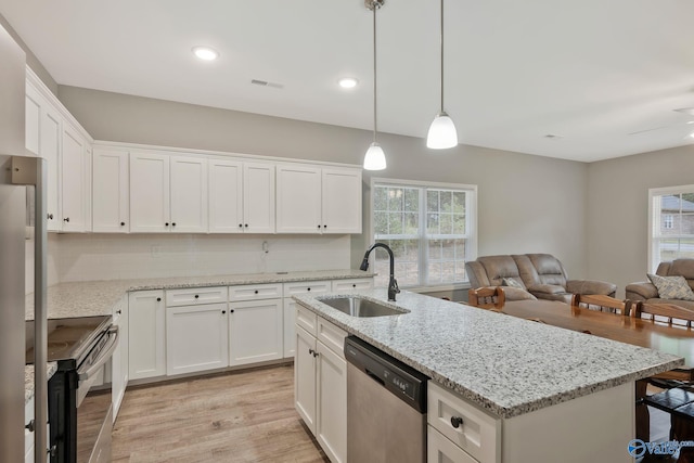 kitchen featuring a wealth of natural light, stainless steel appliances, white cabinetry, and sink