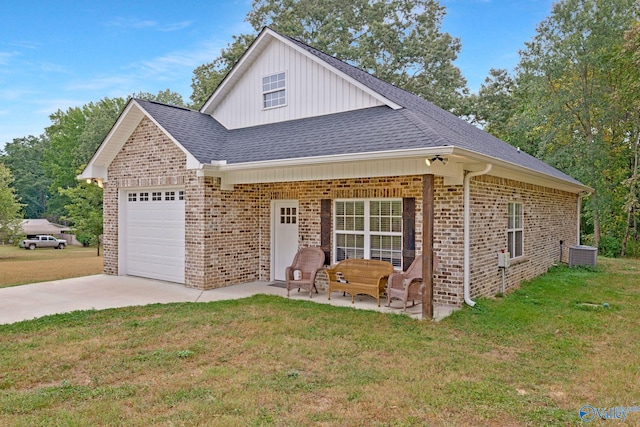 view of front of property with a garage, central AC unit, and a front lawn