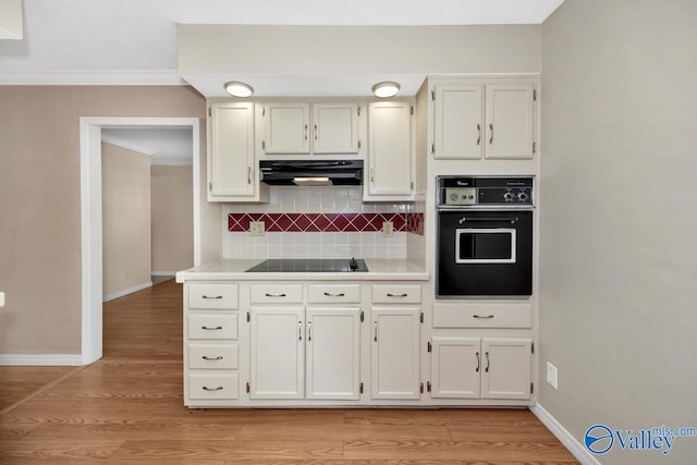 kitchen featuring light hardwood / wood-style floors, white cabinetry, black appliances, and decorative backsplash