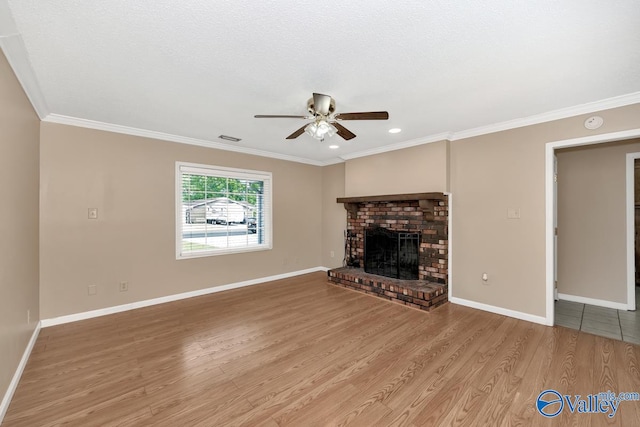 unfurnished living room featuring crown molding, hardwood / wood-style floors, ceiling fan, and a brick fireplace