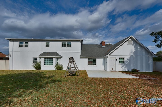 rear view of house with a lawn and a patio