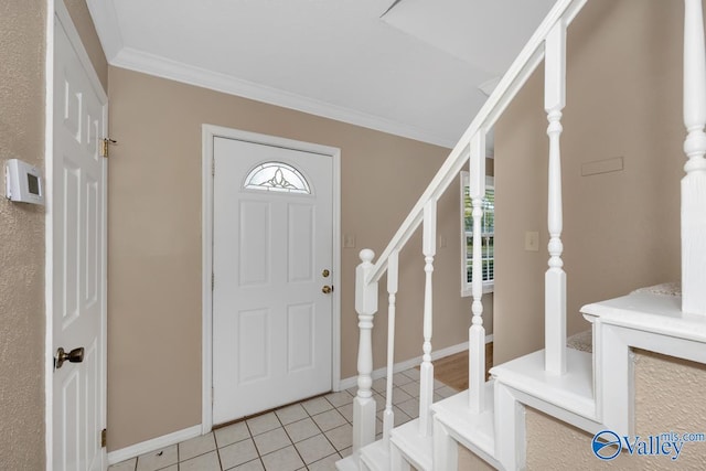 foyer entrance featuring light tile patterned floors and crown molding