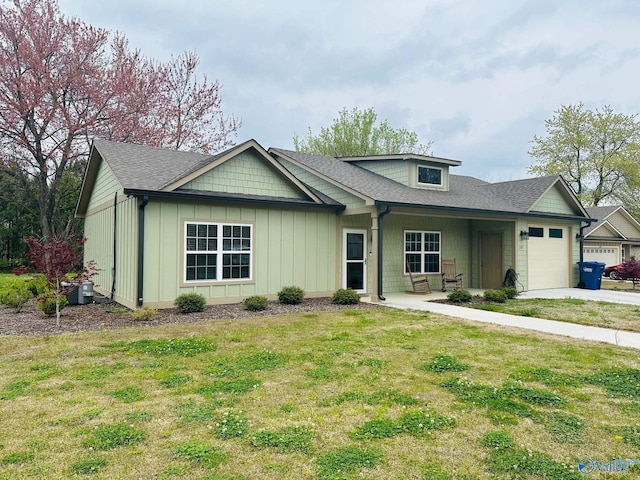 view of front of property featuring a garage, a front yard, and a porch