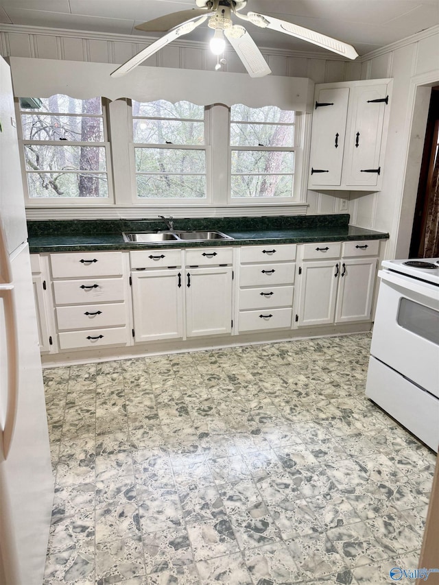 kitchen with white appliances, sink, ceiling fan, ornamental molding, and white cabinetry