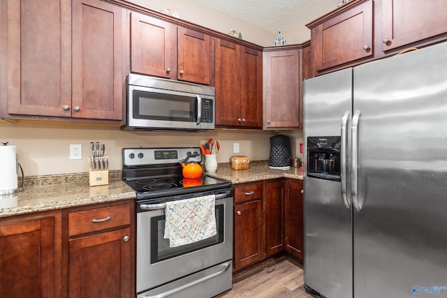 7110 New Bethel Rd, Hokes Bluff, AL 35903 - kitchen with stainless steel appliances, light wood-style flooring, light stone countertops, and a textured ceiling