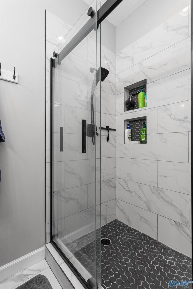 7110 New Bethel Rd, Hokes Bluff, AL 35903 - bathroom with marble look tiles, a shower stall, and baseboards