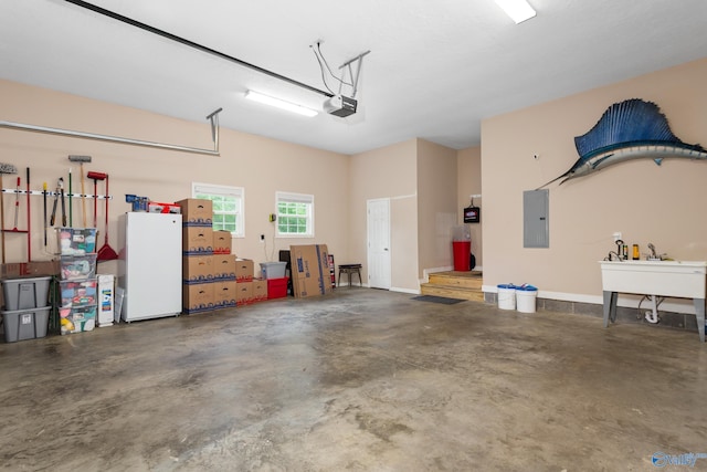 7110 New Bethel Rd, Hokes Bluff, AL 35903 - garage with a garage door opener, electric panel, and freestanding refrigerator