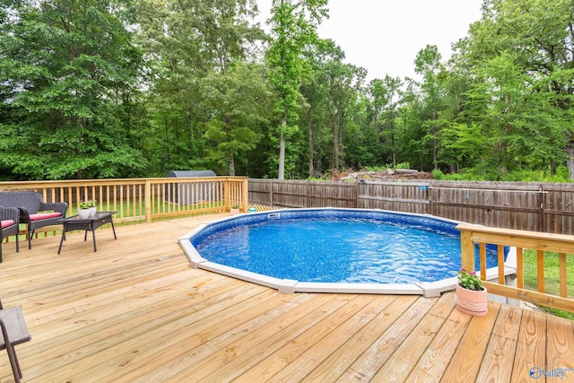 7110 New Bethel Rd, Hokes Bluff, AL 35903 - view of swimming pool featuring a wooden deck, a fenced backyard, an outdoor hangout area, and a storage shed