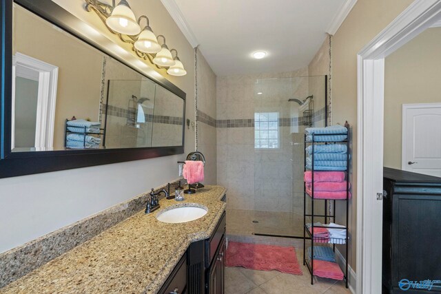 bathroom with vanity, tiled shower, tile patterned floors, and crown molding