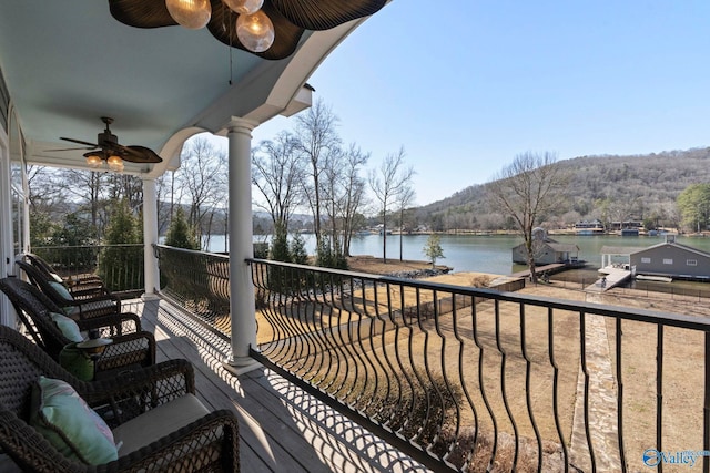 balcony with a water view and ceiling fan