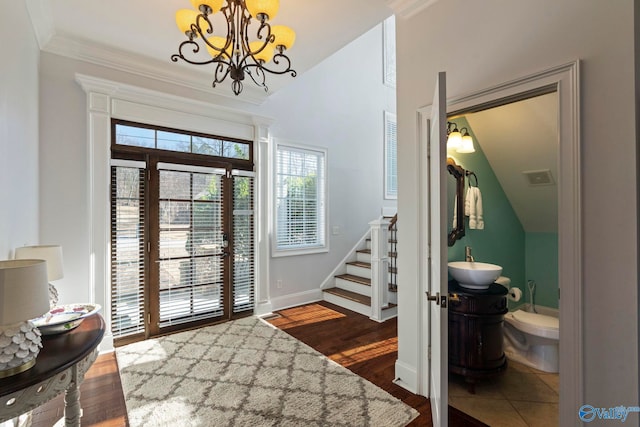 entryway featuring a chandelier, dark hardwood / wood-style floors, lofted ceiling, and sink