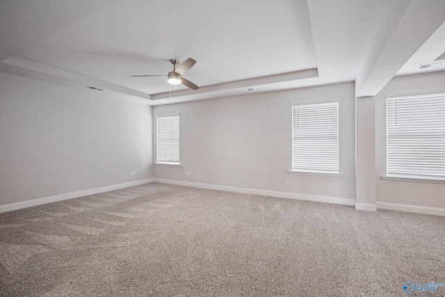 spare room featuring carpet flooring, ceiling fan, and a tray ceiling