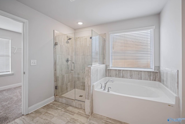 bathroom featuring shower with separate bathtub