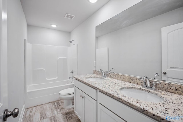 full bathroom featuring washtub / shower combination, vanity, and toilet