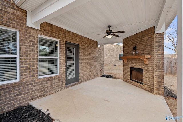 view of patio featuring an outdoor brick fireplace and ceiling fan