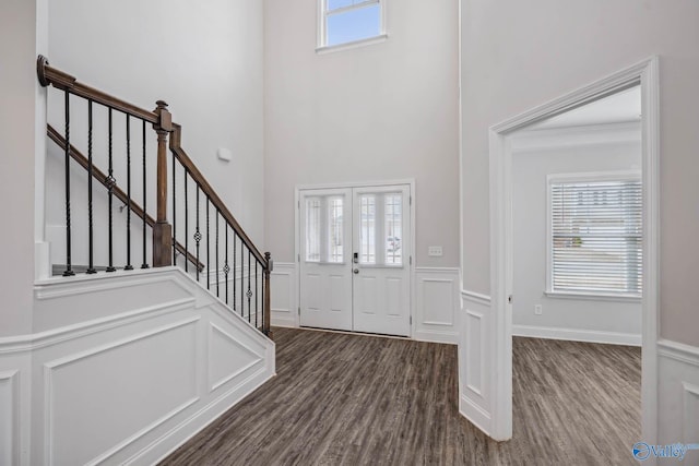 entryway with dark wood-type flooring, french doors, a healthy amount of sunlight, and a high ceiling