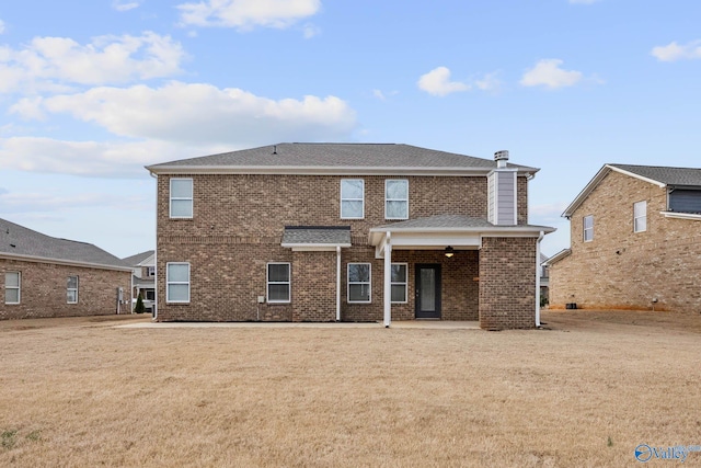 rear view of property featuring a lawn and a patio area