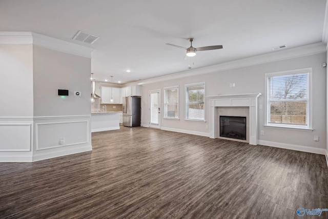 unfurnished living room with crown molding, a wealth of natural light, and dark hardwood / wood-style floors