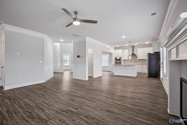 unfurnished living room featuring ornamental molding, dark hardwood / wood-style floors, and ceiling fan