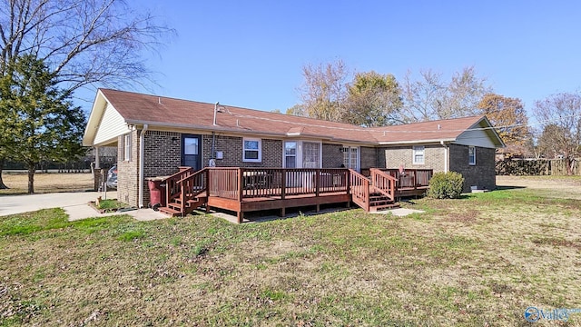 rear view of house featuring a lawn and a wooden deck