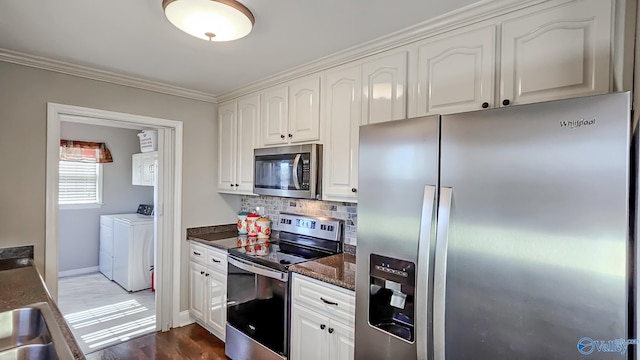 kitchen with washing machine and dryer, white cabinets, and appliances with stainless steel finishes