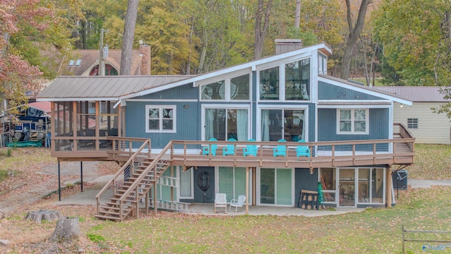 rear view of house with a lawn, a patio area, a sunroom, and a deck