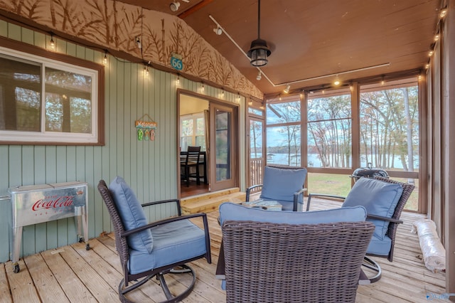 sunroom featuring track lighting, a healthy amount of sunlight, and lofted ceiling