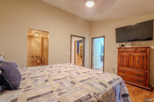 bedroom featuring light wood-type flooring, a closet, vaulted ceiling, and ceiling fan