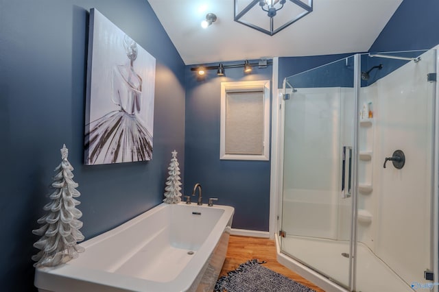 bathroom with wood-type flooring, shower with separate bathtub, and lofted ceiling