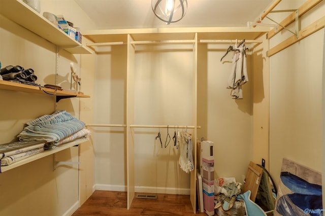 walk in closet with dark wood-type flooring