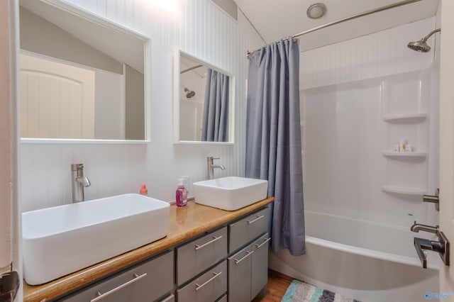 bathroom with hardwood / wood-style floors, vanity, shower / tub combo, and vaulted ceiling