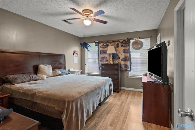 1004 Carter Grove Rd, Hazel Green, AL 35750 - bedroom featuring a textured ceiling, visible vents, ceiling fan, and light wood-style flooring