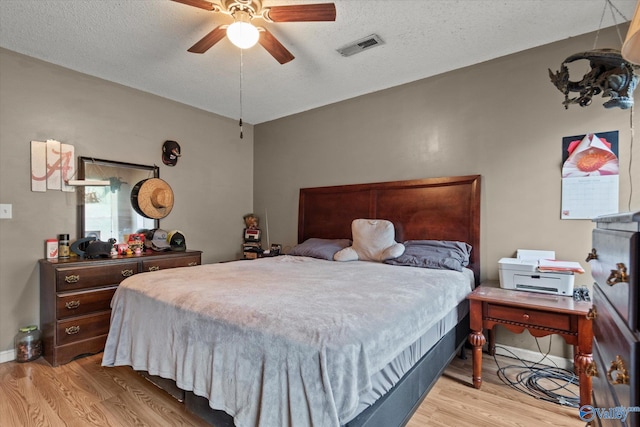 1004 Carter Grove Rd, Hazel Green, AL 35750 - bedroom with light wood finished floors, a textured ceiling, visible vents, and a ceiling fan