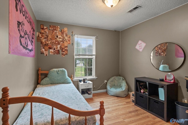 1004 Carter Grove Rd, Hazel Green, AL 35750 - bedroom featuring a textured ceiling, visible vents, baseboards, and light wood-style floors