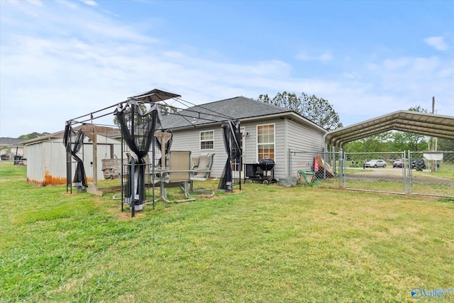 1004 Carter Grove Rd, Hazel Green, AL 35750 - back of house with an outdoor structure, a gate, a detached carport, fence, and a yard