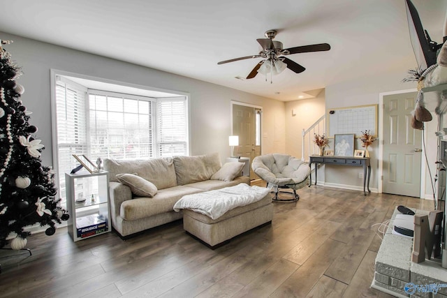 living room featuring ceiling fan and dark hardwood / wood-style floors