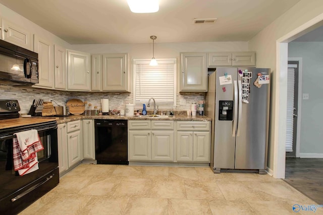 kitchen featuring black appliances, stone countertops, decorative backsplash, and sink